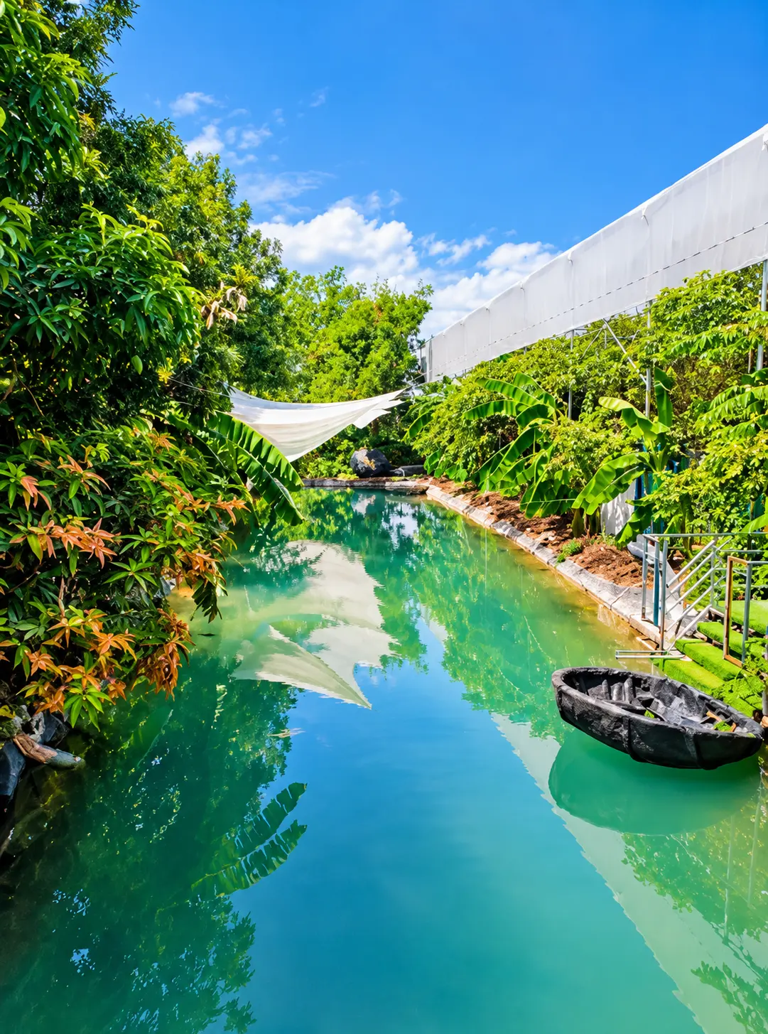 Still green canal with a coracle and banana plants